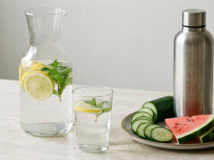 Limon ve naneli su sürahisi, dolu bir bardak, çelik matara, salatalık ve karpuz dilimleri